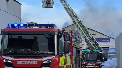 Emma Baugh/BBC Aerial platform at the site of the fire by morning