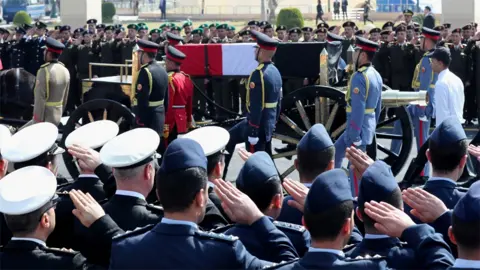 EPA Egyptian military personnel salute a horse-drawn carriage transporting the coffin of Hosni Mubarak at the Tantawi mosque in Cairo (26 February 2020)