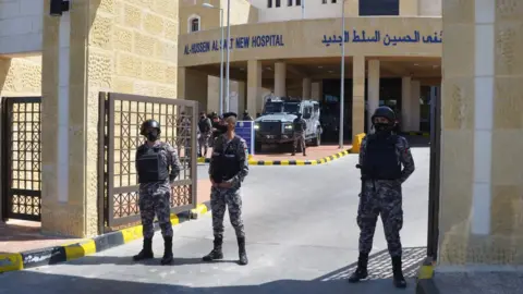 Reuters Gendarmerie officers stand guard at the gate of the new Salt government hospital in Jordan, 13 March 2021