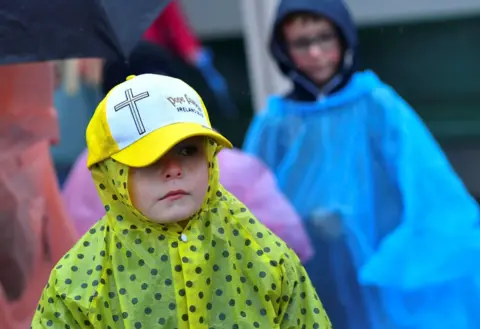 Reuters A child wearing a Pope Francis hat