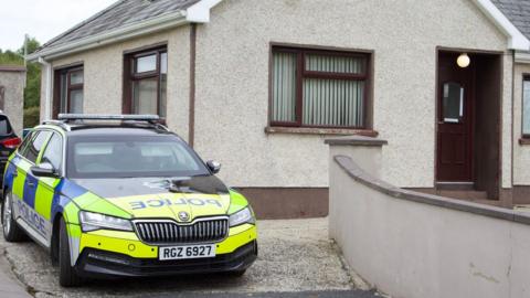 A police car at the house where a pensioner was found dead in Crossmaglen, County Armagh