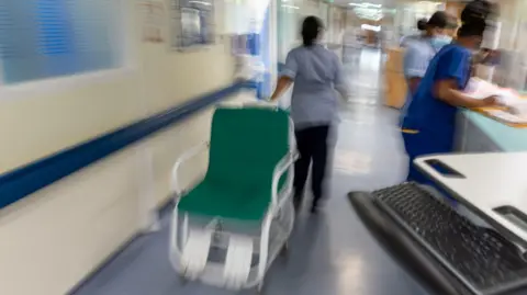 NHS ward staff hurry to care for patients.