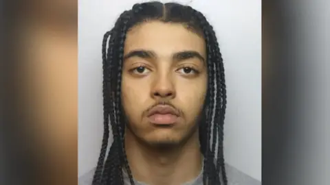 Thames Valley Police Jack Patterson - has dreadlocked, dark hair and a black moustache 