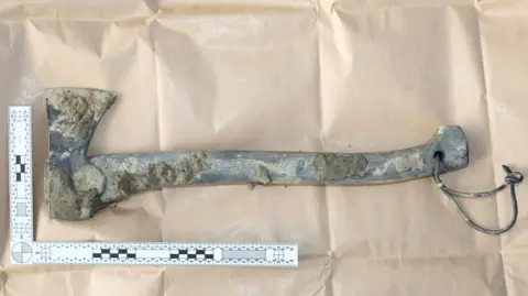 Sussex Police A police photo shows the axe, covered in mud.
