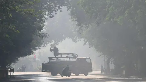 Getty Images A truck with a smog gun spraying water to control air pollution on the streets of Delhi. 