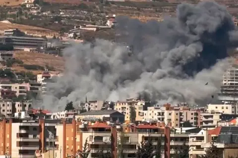 Smoke rises from a building that was set on fire by a missile attack.