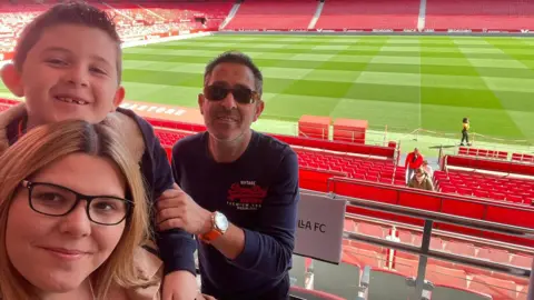 Family Gemma, Eduardo and nine-year-old Edward at Sevilla's stadium in Spain