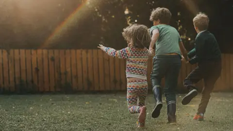 Getty Images Three children running in a garden