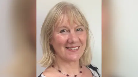 Jean Glasberg A headshot of Jean Glasberg, who has shoulder length blond hair and is smiling at the camera. She has a black and white dress on and a silver and red necklace.