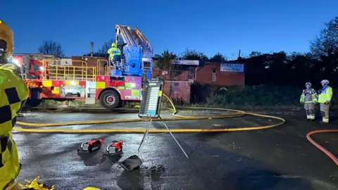 Firefighters with a building in the background