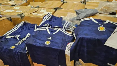 City of Edinburgh Council Several blue Scotland tops laid out on boxes
