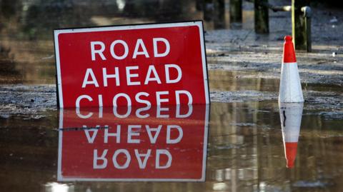 A road sign partially submerged in water