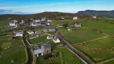 MANX SCENES Cregneash village from above show a network of stone built buildings, some white washed, among green fields.