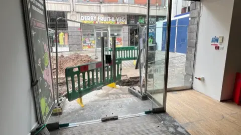 View from shop showing doorway and roadworks beyond