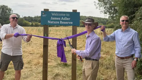 Mick cuts the ribbon to open the James Adler nature reserve 