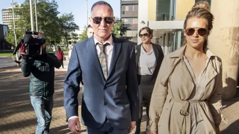 PA Media Paul Gascoigne arriving at Teesside Crown Court with personal manager Katie Davies