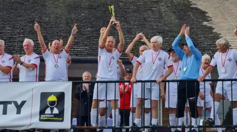 Geoff is in the middle of the England squad and lifting the trophy.