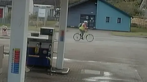Crown Office A CCTV image of a cyclist taken from the forecourt of a garage