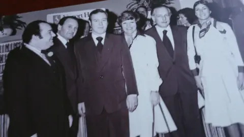 Francine Carville A group of four men and two women lined up for a photo. The photo is in black and white.