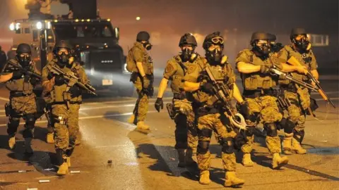 AFP Armed police officers in Ferguson, Missouri (18 August 2014)