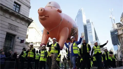 PA Media Performers carried an inflatable pig though the streets
