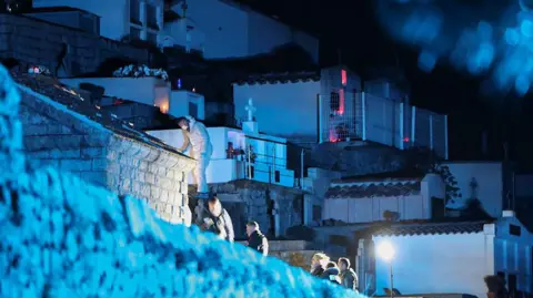 Police officers work at the crime scene where former Corsican nationalist leader Alain Orsoni has been shot dead during his mother funeral, in Vero, on the French Mediterranean island of Corsica