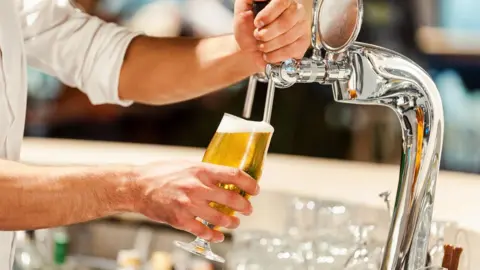 Getty Images Bartender pulls pint of beer