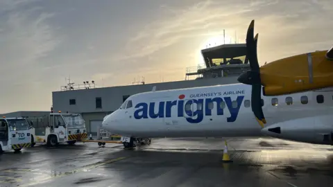 BBC An Aurigny aeroplane at an airport terminal 