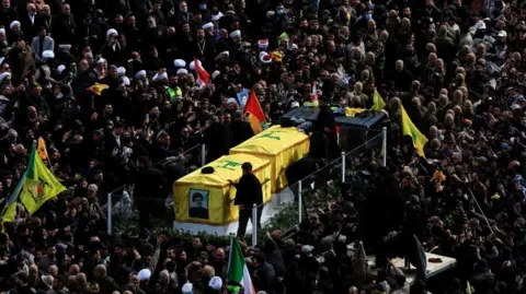 Reuters A vehicle carries the coffins of the former leaders of Hezbollah Hassan Nasrallah and Hashem Safieddine through a dense crowd