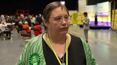 Esther Reeves is dressed in green and is pictured at the Coventry City Council election count