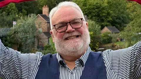 Alan Gregory Alan standing in a garden.