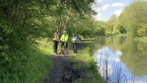 PA Media Officers speak to a passer-by about the discovery in Rough Wood Country Park