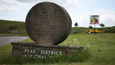 EPA A stone monument with the words PEAK DISTRICT NATIONAL PARK on it.