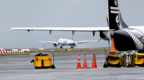 Getty Images An Emirates plane touches down at Auckland International Airport