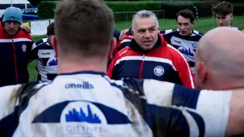 Family handout via Metropolitan Police Matt Ratana pictured at the centre of a rugby huddle in his role as East Grinstead rugby coach.