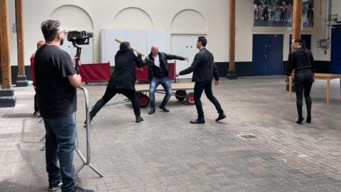Four people rehearsing a fight scene