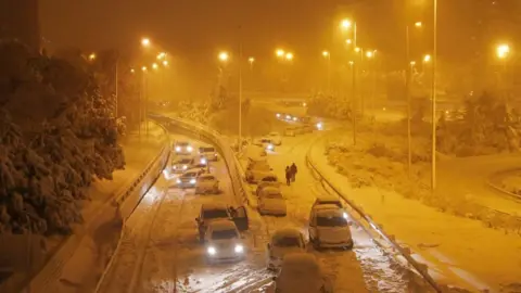 Reuters People walk after leaving their vehicles on a road in Madrid