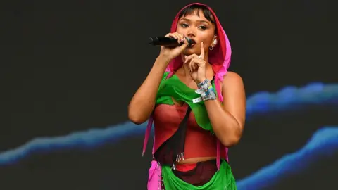 Getty Images Joy Crookes wears a colourful dress of pink, red and green during her performance on the Other stage during day five of Glastonbury Festival on 29 June 2025 in Glastonbury, England.
