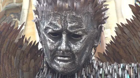 The knife angel. A 27ft-tall (8m) sculpture in the shape of an angel pulling a sad face, made from 100,000 blades.