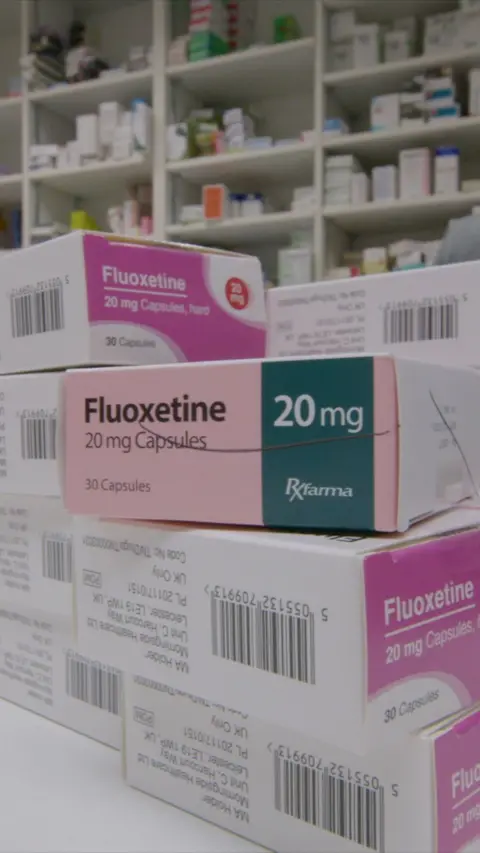 A stack of small boxes of medicine in a pharmacy setting