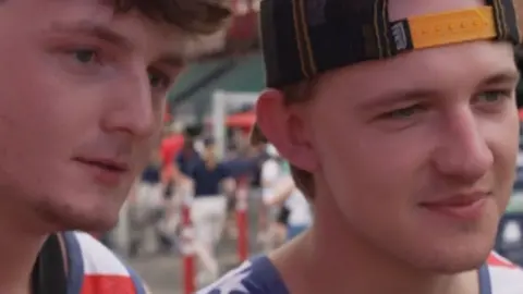 Two young men attend a Boston Red Sox game