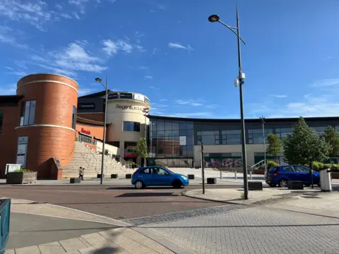 Regent Circus entrance plaza viewed across the road on a sunny day, an entrance to the town centre