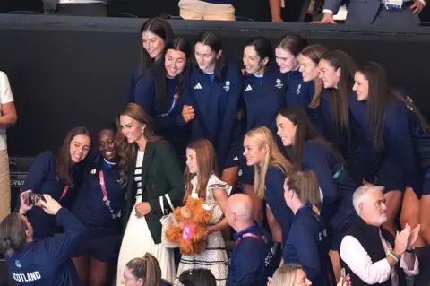 PA Media Princess Catherine and Charlotte take a photo with the Team Scotland women's netball team