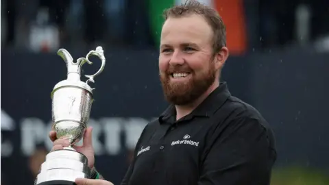EPA/FACUNDO ARRIZABALAGA Shane Lowry of Ireland with the claret jug trophy as he celebrates winning the British Open Golf Championship at Royal Portrush, Northern Ireland, 21 July 2019.