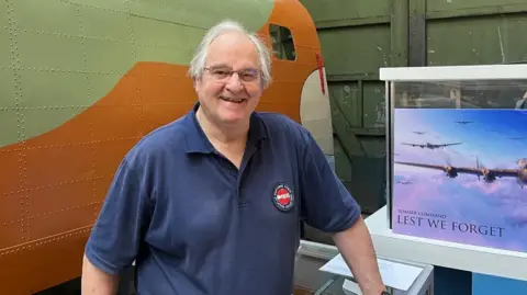 Graham Horner in glasses and blue polo shirt looking at the camera