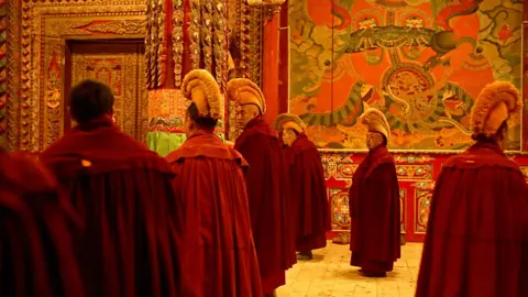 Xiqing Wang/ BBC Tibetan Monks in morning prayers in Kirti monastery