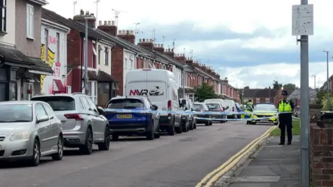 BBC The cordon in St Paul's Street in Swindon. It is a residential street, with rows of terraced houses and parking to the left hand side. There are double yellow lines on the right of the carriageway.