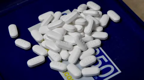 Tablets of the opioid-based hydrocodone on a blue table