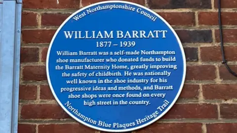 James Grant/BBC A blue plaque for William Barratt on a brick wall. 