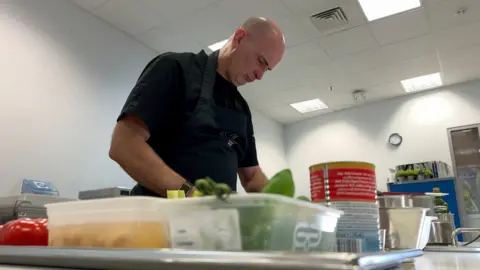 Pat Clifford preparing ingredients in his kitchen
